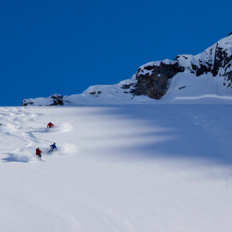 Heliski guide Jökull Bergmann leading a group heli skiers down an incredible powder run on a glacier on the east coast of Greenland.