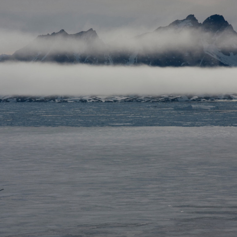 Misty morning over the half frozen fjords of East Greenland where Arctic Heli Skiing operates heli skiing and snowboarding trips from March through June.