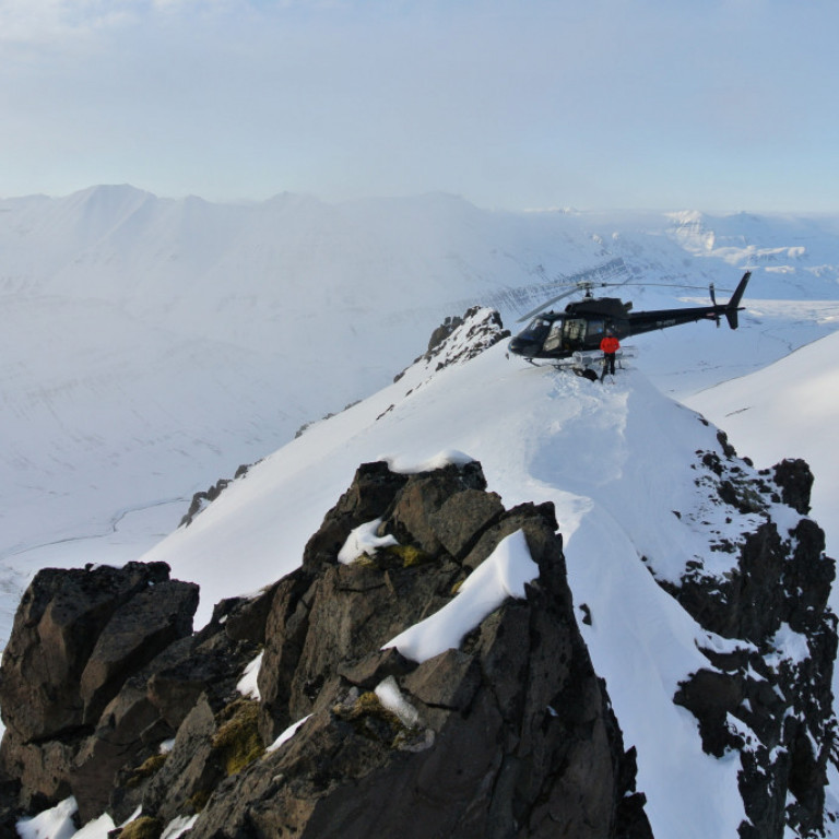 The helicopter on top of a peak during filming for Warren Miller