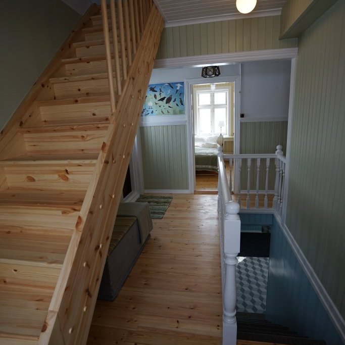 Main level hallway. Stairs to the 5 bedrooms and bathroom upstairs, stairs down to the lower level which has 2 toilets, 2 showers washer/dryer and a gear storage area