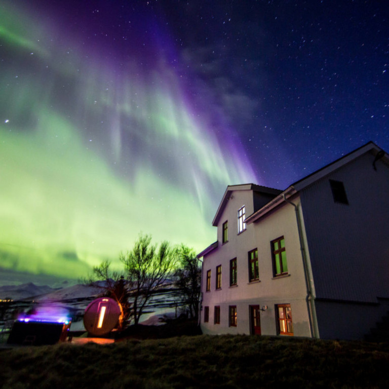 Karlsá Lodge at night with the Northern Lights in March